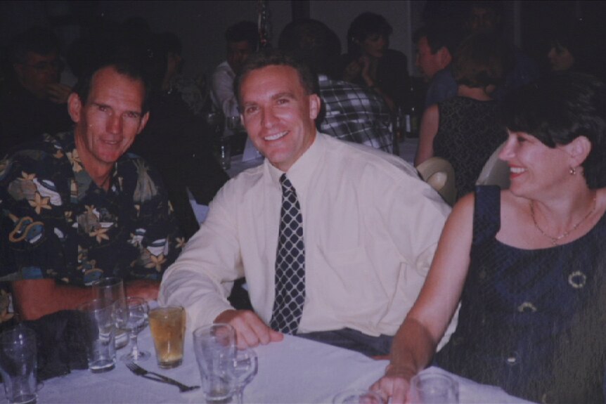 An old photo of Broncos coach Wayne Bennett, CEO Paul White and his wife Angela sitting at a table