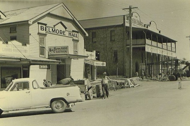 A black and white image of a wooden hall building in a country town.