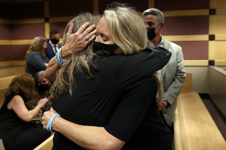 The mother and widow of two people killed in the Parkland shooting embrace in court after Cruz's guilty plea.