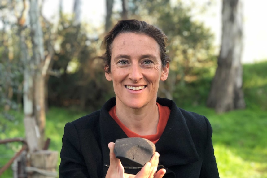 Tamara Davis holds a piece of rock in her hands.