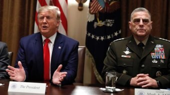 Donald Trump speaks as the Chairman of the Joint Chiefs of Staff, General Mark Milley (right), listens.