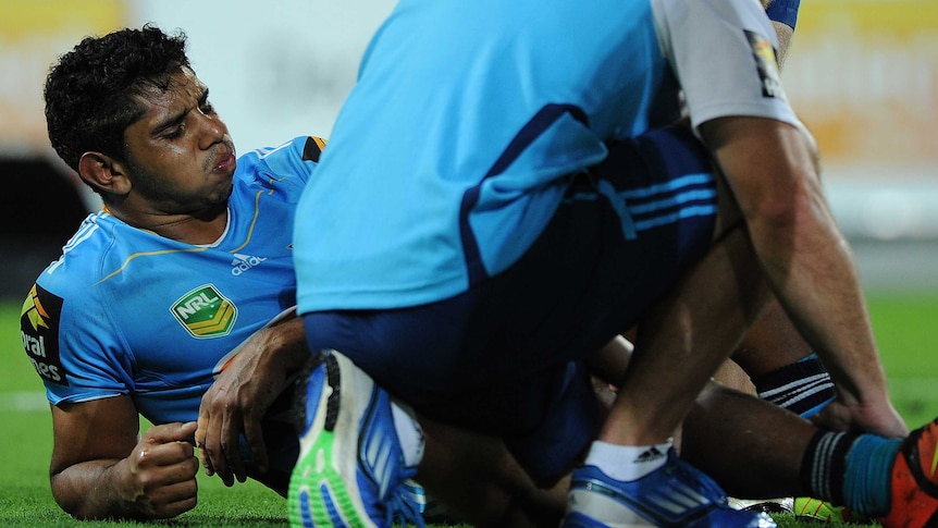 Gold Coast Titans' Albert Kelly receives attention after being injured against Brisbane.