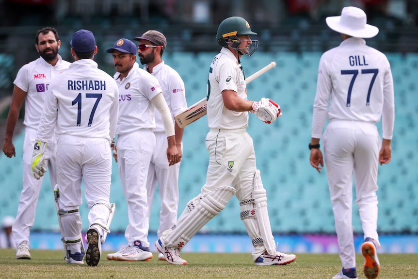 Indian players congratulate each other as an Australian A batter walks off the field.