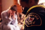 Tasmanian police officer comforts a woman in her home