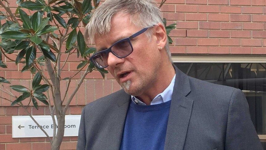 A head and shoulders shot of Bankwest Curtin Economics Centre Associate Professor Christof Pforr standing outdoors talking.