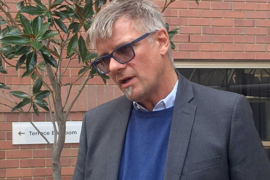 A head and shoulders shot of Bankwest Curtin Economics Centre Associate Professor Christof Pforr standing outdoors talking.