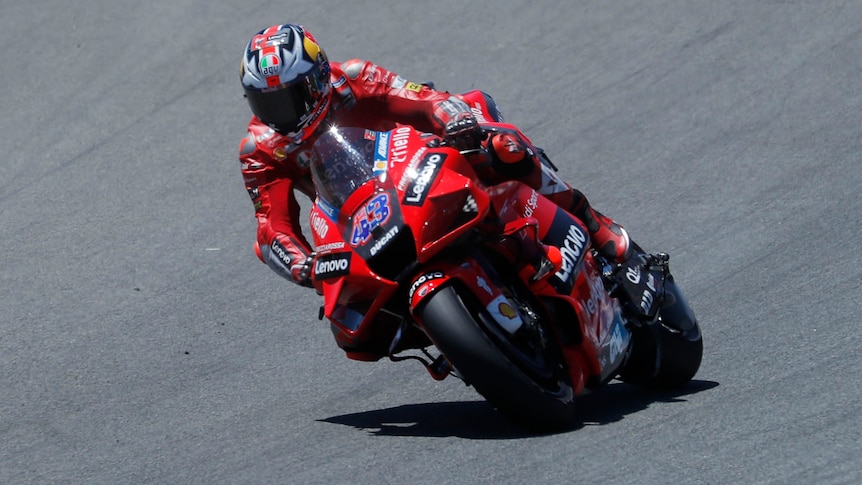 Jack Miller riding a red motorcycle on a racetrack