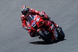 Jack Miller riding a red motorcycle on a racetrack