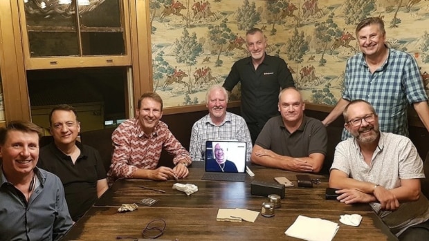 Men sitting around a wooden table.