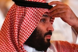 Saudi Arabia's crown prince Mohammed bin Salman lifts his hand to his forehead