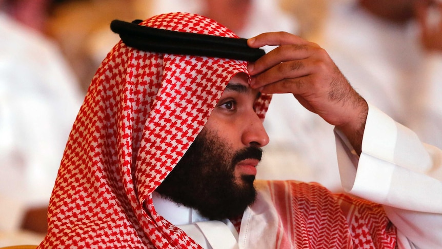 Saudi Arabia's crown prince Mohammed bin Salman lifts his hand to his forehead