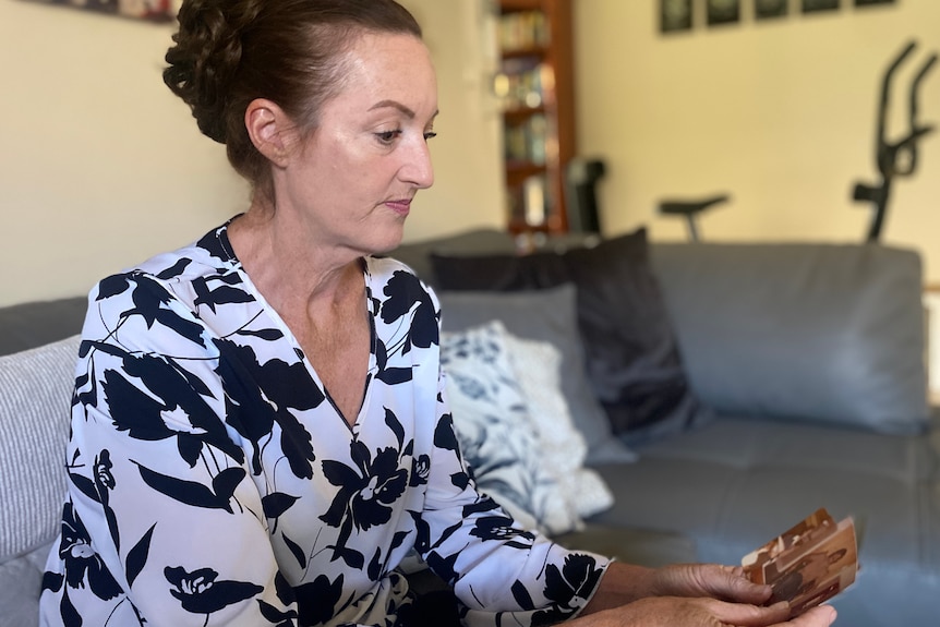 Inland Hotel mass murder survivor Bernadette Schiller looks at photographs.