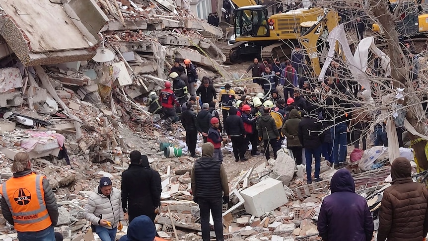 People walk around rubble