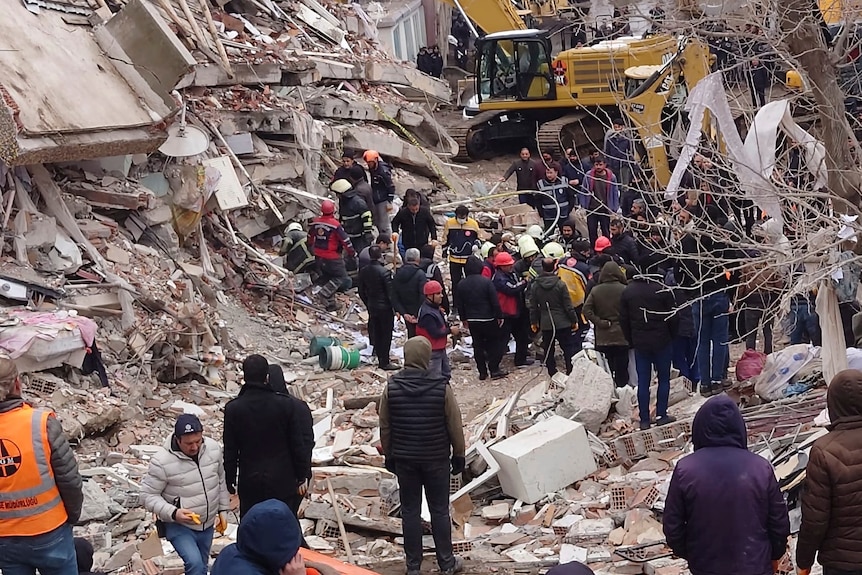 People walk around rubble