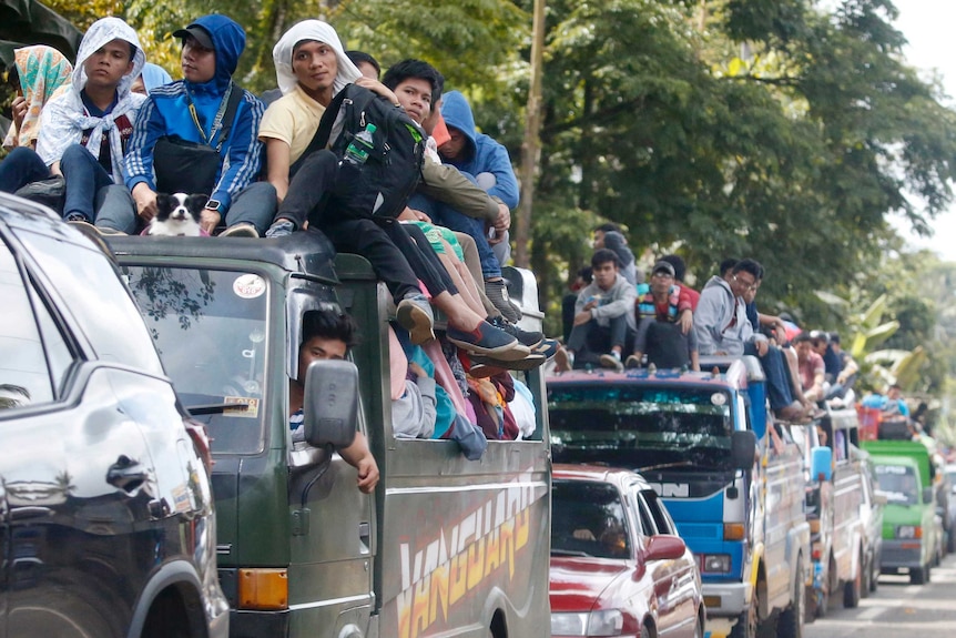 A line of packed cars drives up the road out of Marawi City.