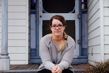woman with glasses sitting on porch