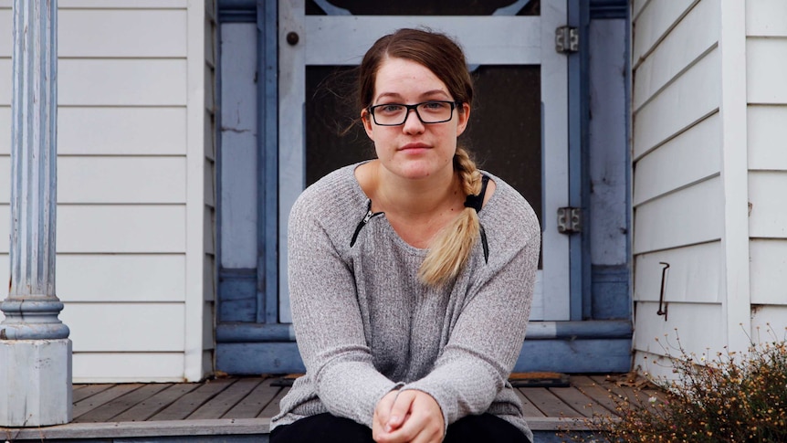 woman with glasses sitting on porch