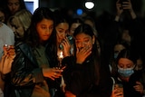 Two women crying at a vigil