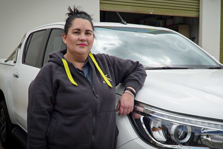 Kyle Kinchela stands next to her white Toyota Hilux.