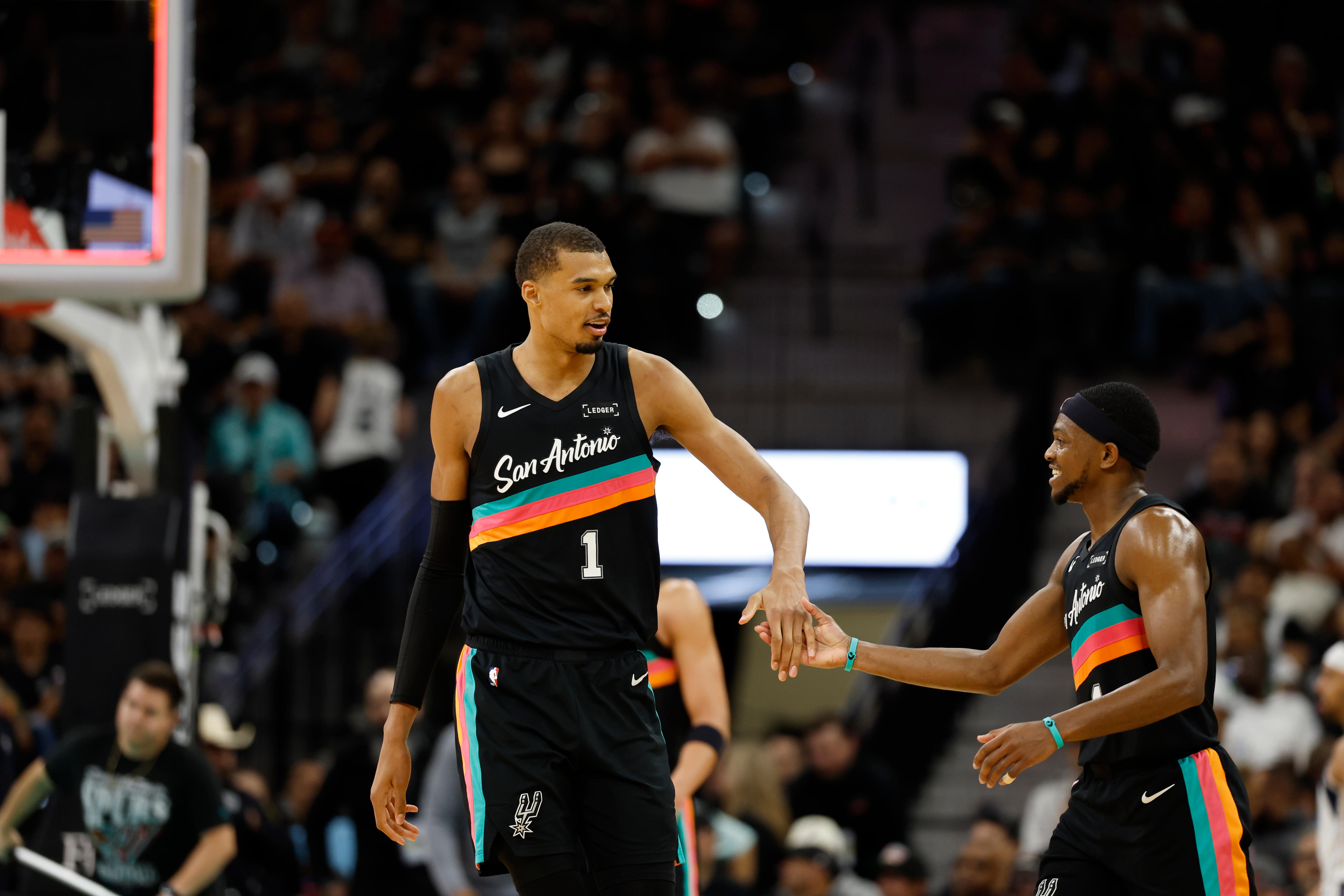 Victor Wembanyama shares a high-five with De'Aaron Fox