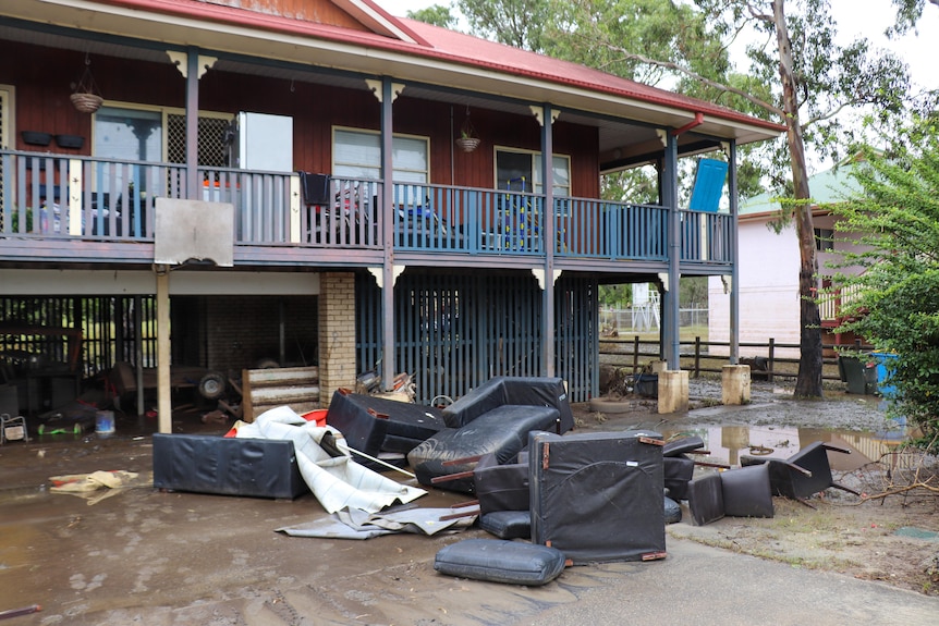 water damaged furniture outside a house damaged by floodwaters