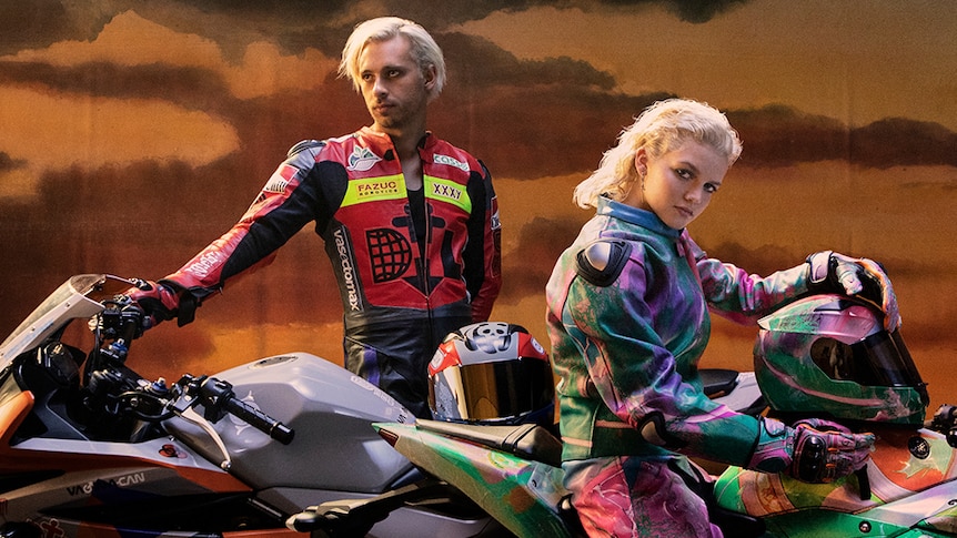 A 2022 press shot Flume and MAY-A posing on motorcycles with sportswear jackets