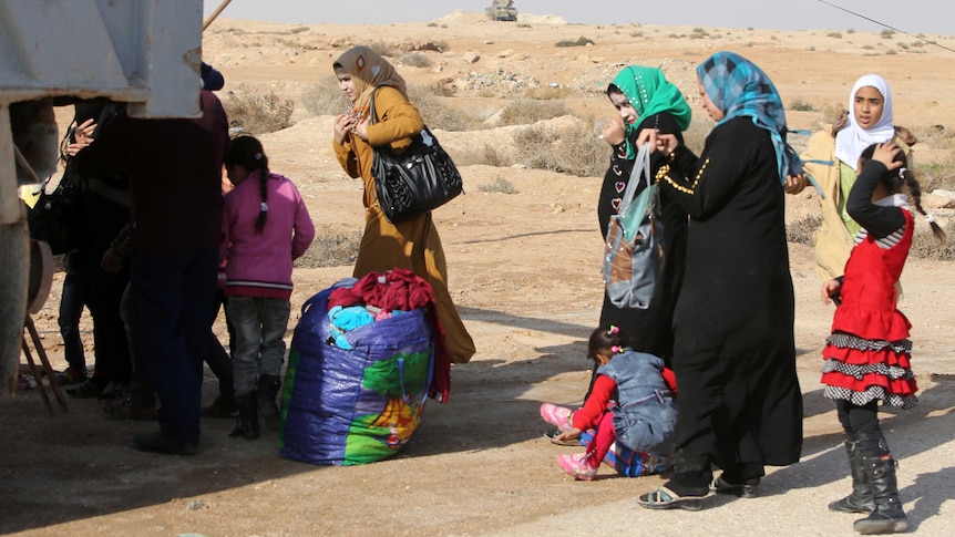 Iraqi women and children who fled Fallujah stand at checkpoint