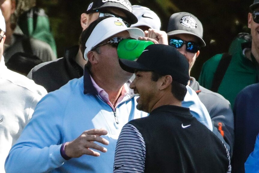 Fan drinks from a beer cup after Jason Day's ball landed in his drink
