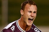 A Manly NRL player screams out and pumps his fists as he celebrates kicking the winning field goal against the Sydney Roosters.