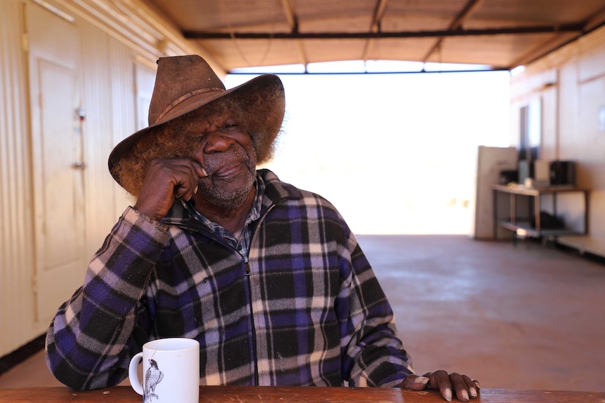 Man sitting down and talking at atble