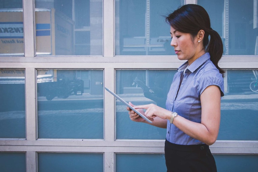 A woman on her iPad outside