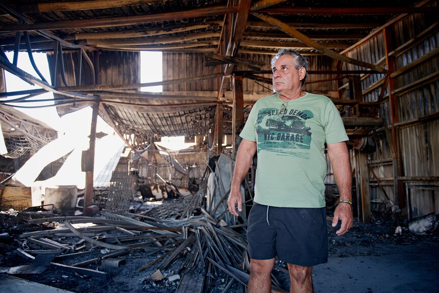 Kerry Kyriacou looks through what remains of his joinery business after a fire gutted the building.
