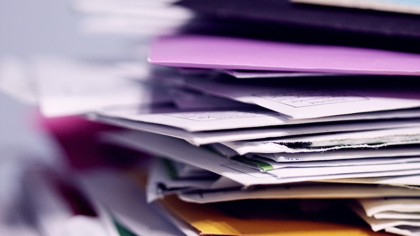 A stack of envelopes and paper pictured up close