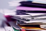 A stack of envelopes and paper pictured up close
