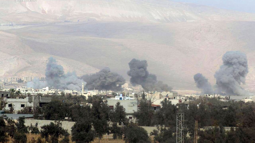 shows smoke and debris rising after Syrian government airstrikes hit in Eastern Ghouta