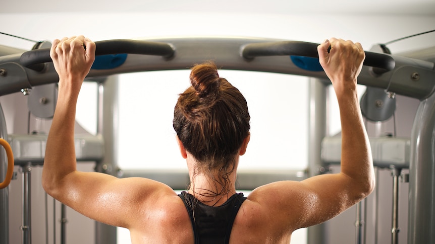 Woman doing chin lifts in the gym