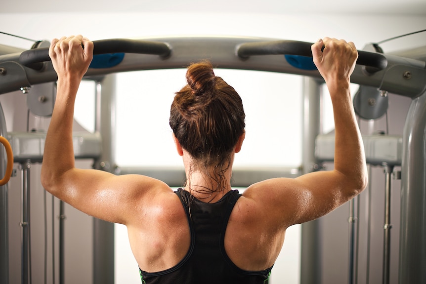 Woman doing chin lifts in the gym