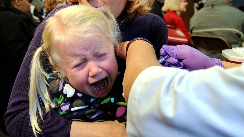 A girl cries as she receives her vaccination