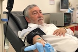 Avi Susskind has a tube going into his arm as he donates plasma.
