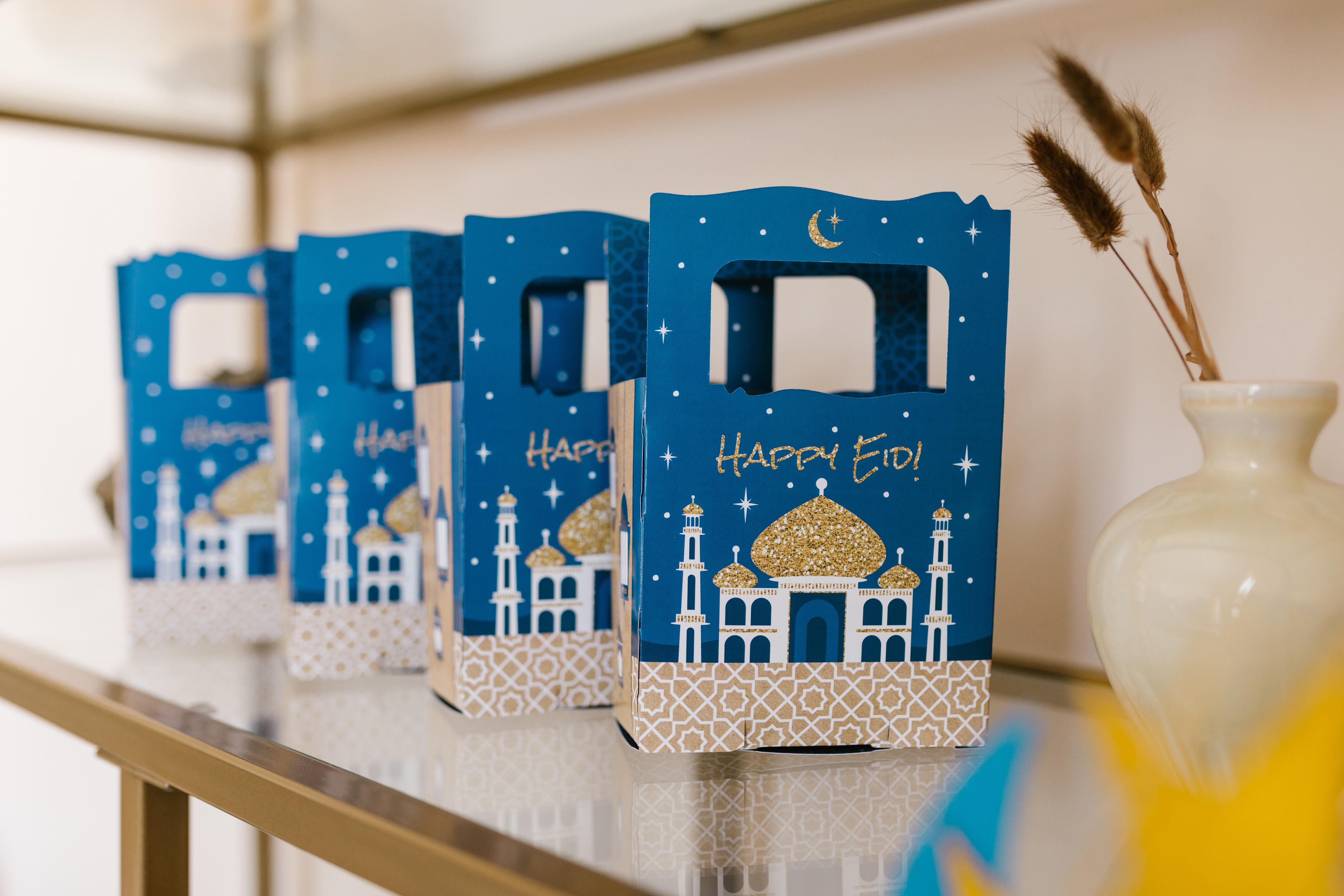 A row of small blue gift bags showing a mosque and the words "Happy Eid!"