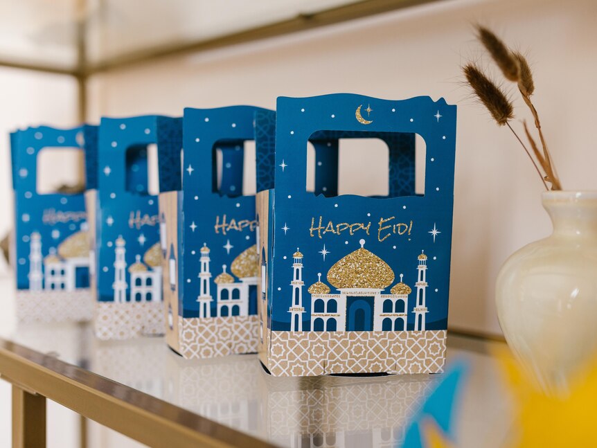 A row of small blue gift bags showing a mosque and the words "Happy Eid!"
