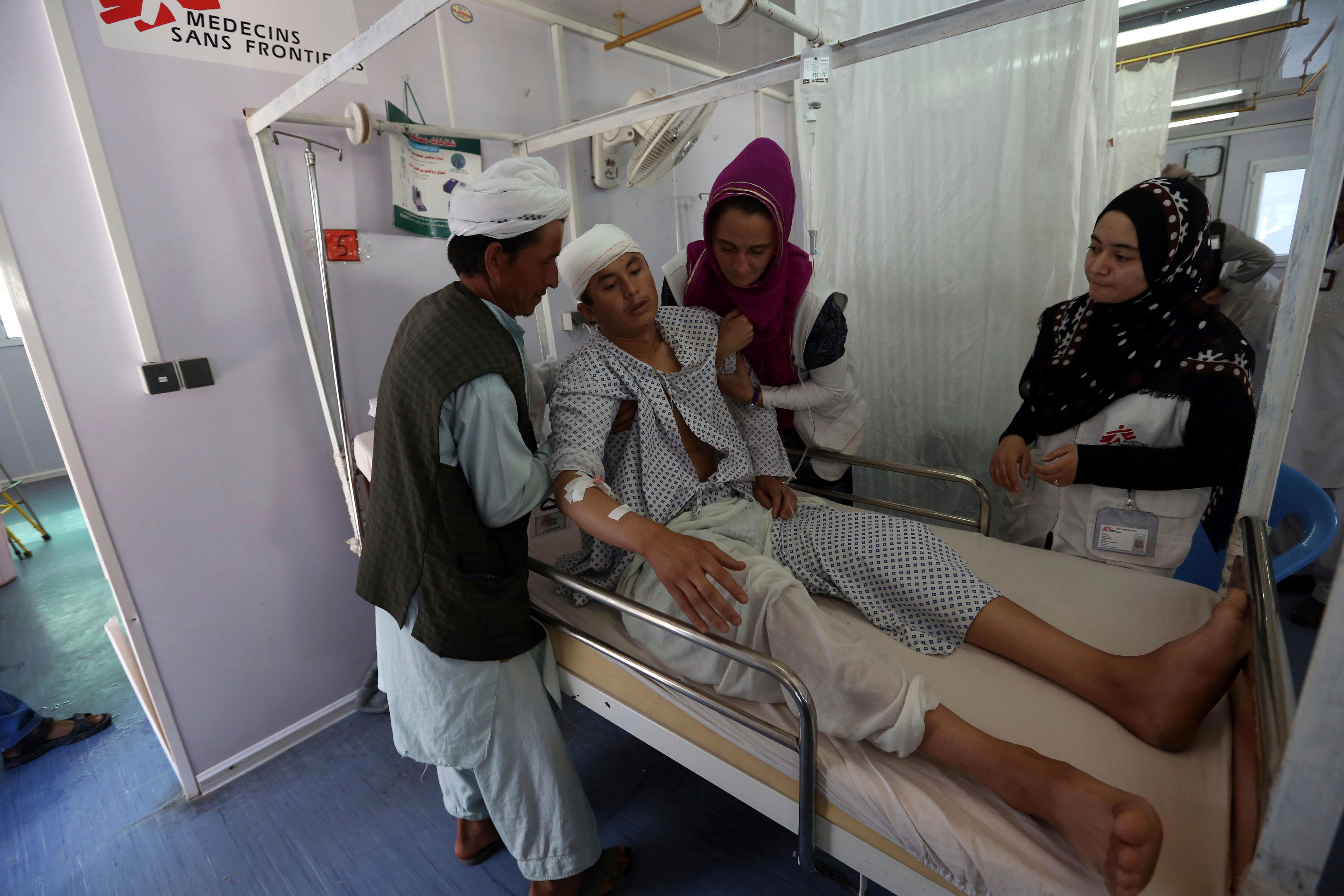 Female medical workers help a young man at a Medecins Sans Frontieres hospital.