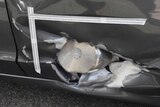 A close-up of a homemade pressure-cooker bomb embedded in a car.
