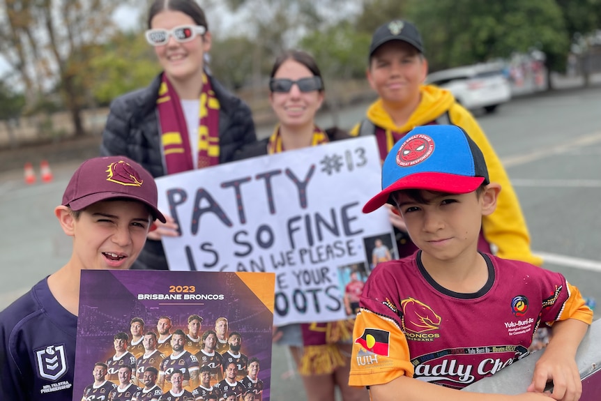 Children hold up handmade Broncos signs