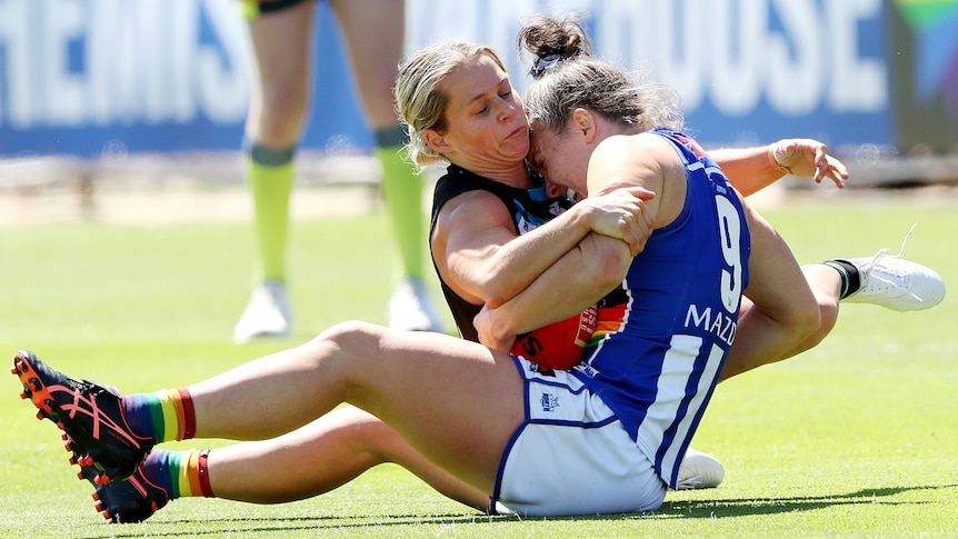 Kate Surman of Port Adelaide tackles Emma Kearney of the Kangaroos