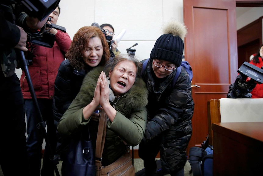 Wang Yulian, whose daughter was among the passengers onboard MH370 is comforted by relatives.