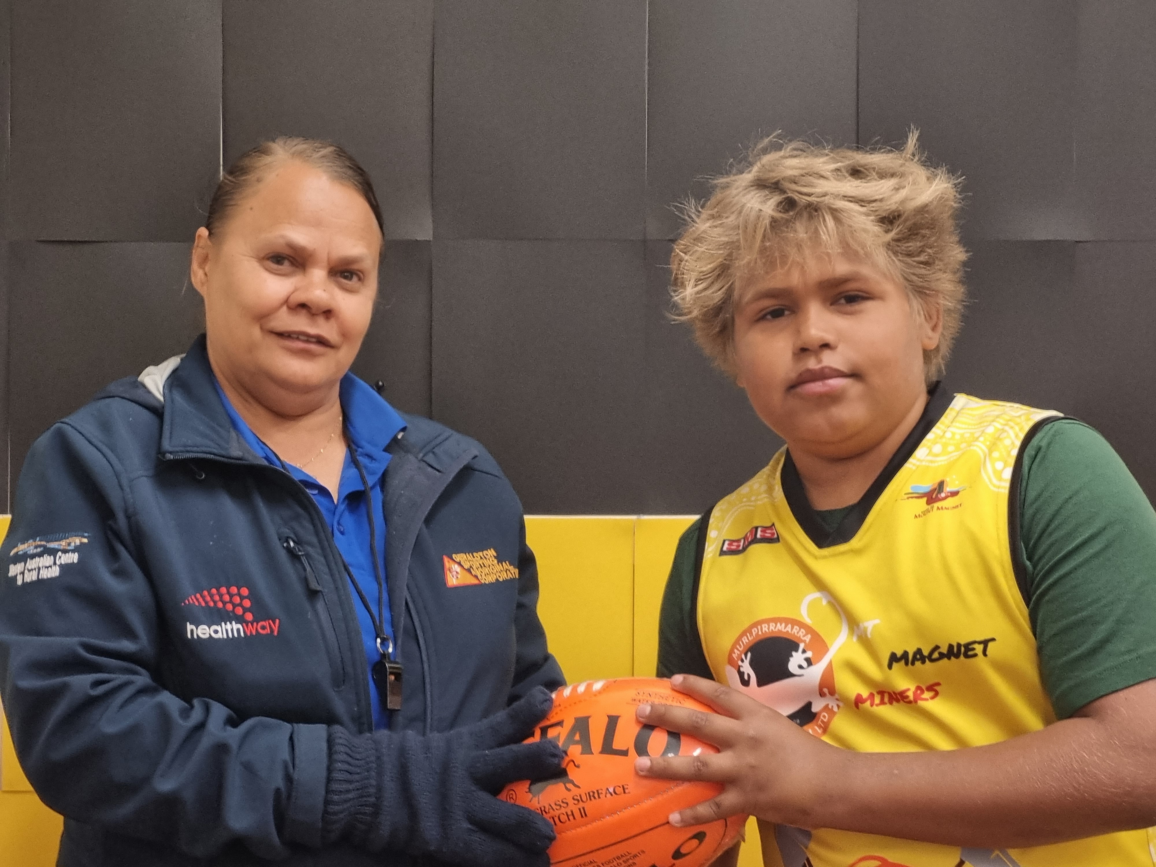 A woman and a boy holding a football