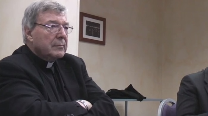 George Pell seated with his arms crossed.