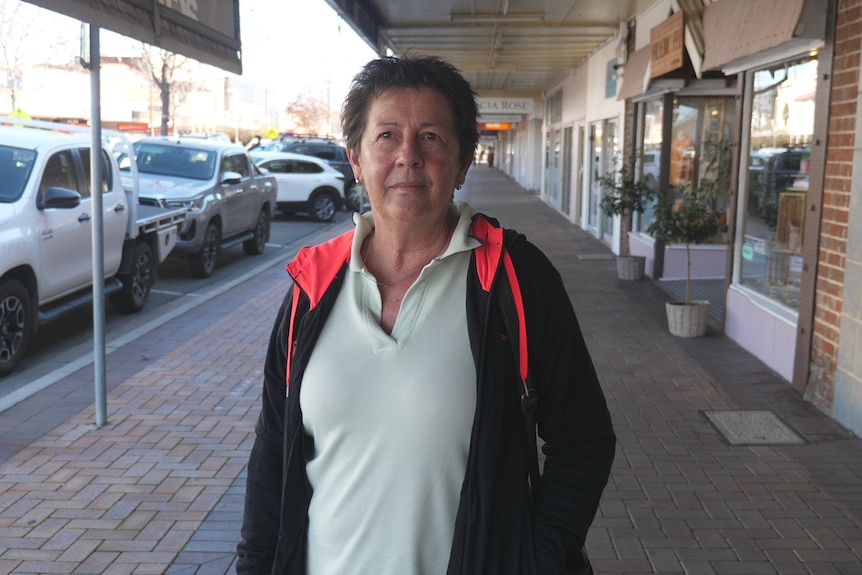 A lady stands on the main street of Gunnedah with a white shirt and black hoodie