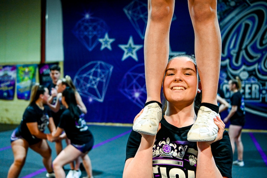 An athlete stands on the shoulders of another athlete.